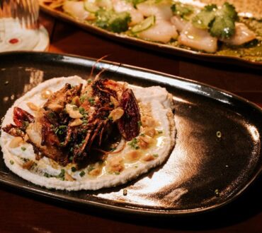 Close-up of a plated meat dish garnished with native greens